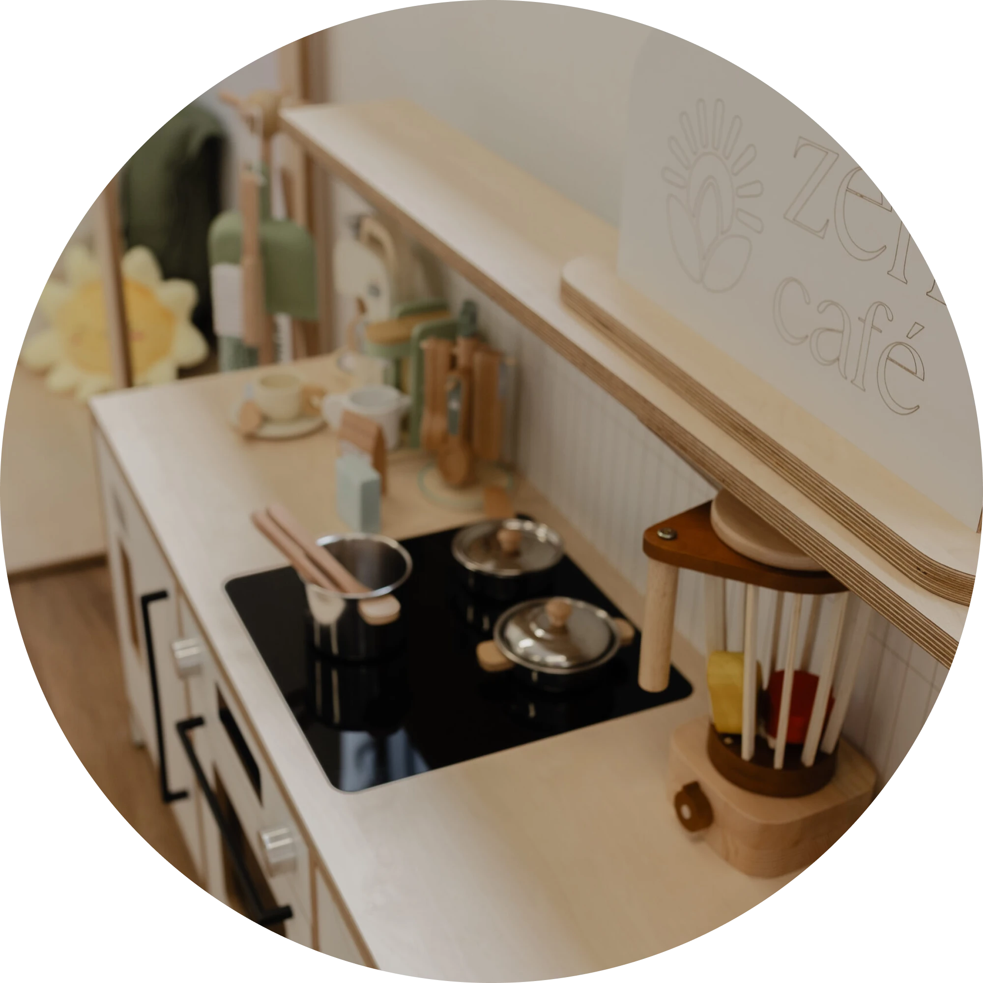 A pretend play kitchen with pots, pans, and a Zen Cafe sign in the Sun Room