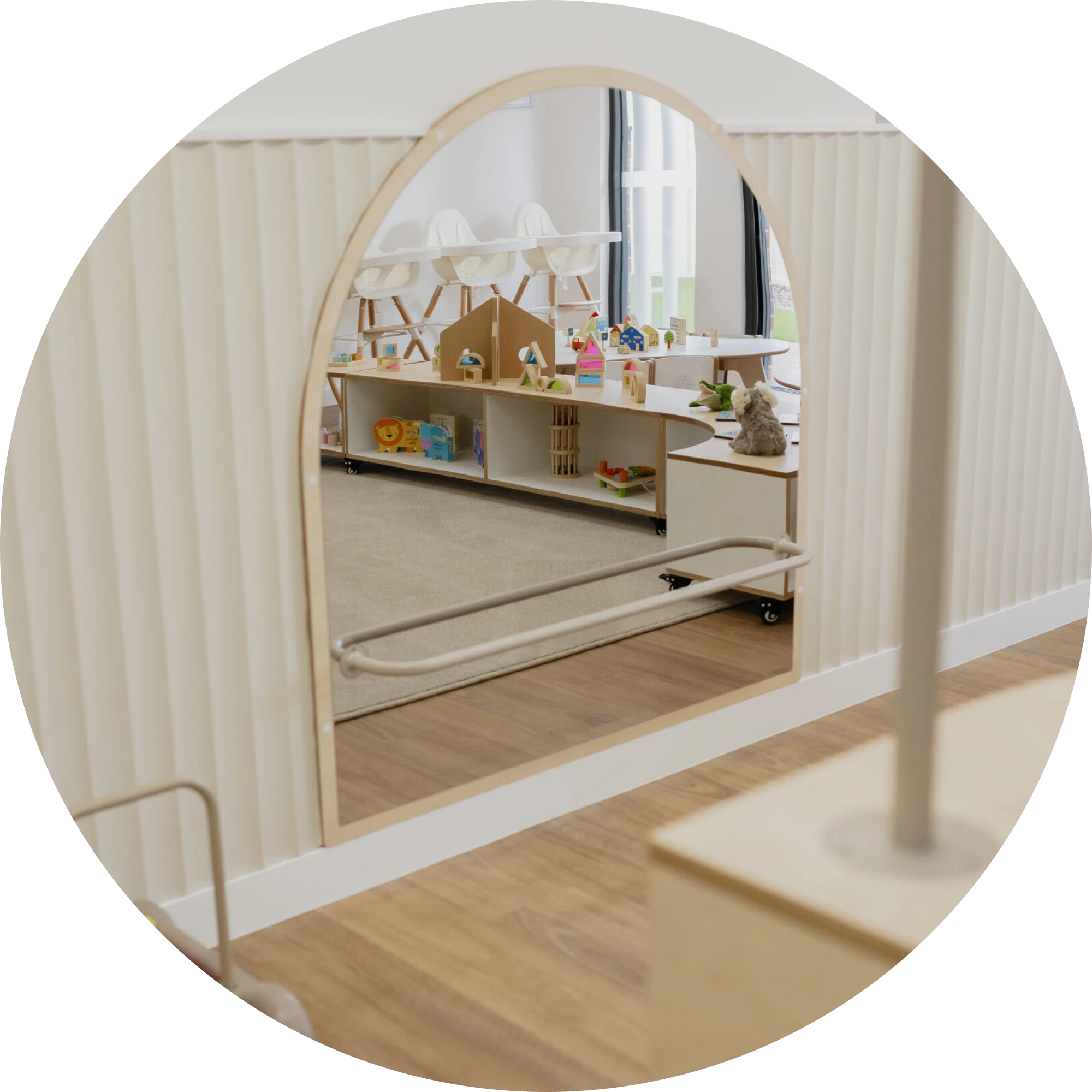 View through an arched doorway into the Stars Room with a shelf of toys and high chairs